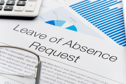 Leave of absence request form on a desk with paperwork. Close up.