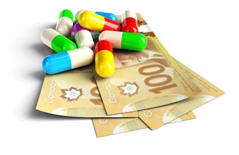 Colorful pill capsules on New Canadian 100 hundred dollar bills to present the high cost of drugs.