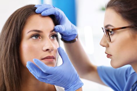 Picture of adult woman having her eye examined by a female doctor.