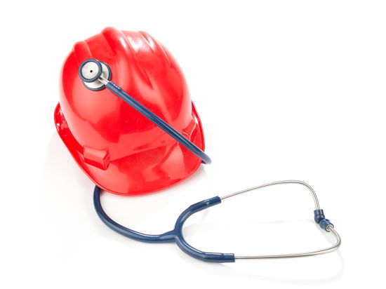 Work place safety concept with red hard hat and stethoscope isolated on white background.