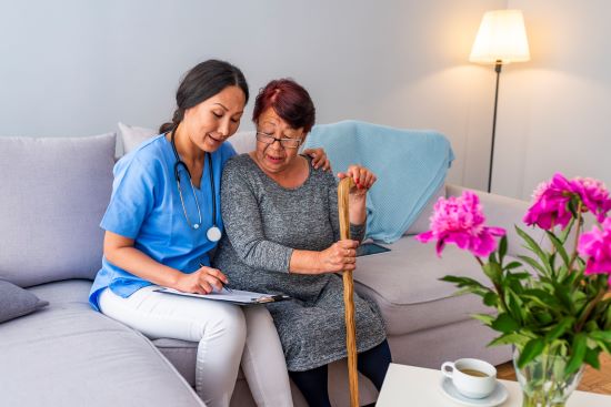 Portrait of young Asian nurse with elderly woman. Helpful volunteer taking care of senior lady at healthcare home. Picture of a senior lady with her friendly caregiver.