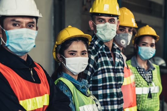 Divers groupes d'employés d'usine avec un masque facial protègent contre l'épidémie de la maladie à virus Corona 2019 ou COVID-19.