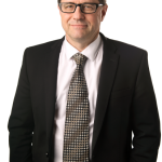 Photo of Eckler Principal Jean Mongrain. Jean is facing the camera straight on and has his hands in his pockets.