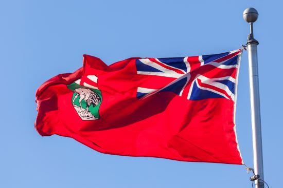 Flag of the province of Manitoba, Canada. Blue sky background