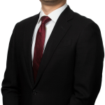 Photo of Eckler Principal Ping Teng Lin. He is wearing a black jacket and black pants, with a white shirt and is standing with his hands crossed looking straight into the camera with a slight smile.